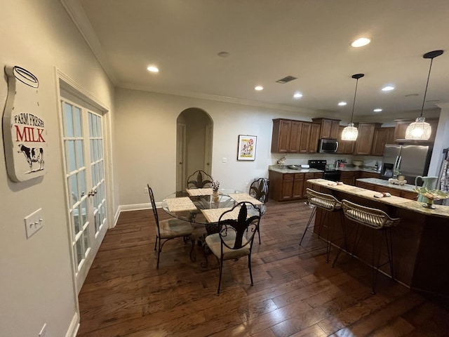 43 Secret St, Freeport, FL 32439 - dining space featuring arched walkways, crown molding, recessed lighting, and dark wood-style floors