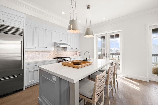 74 Town Hall Rd Unit 3B, Rosemary Beach, FL 32461 - kitchen featuring stainless steel built in fridge, crown molding, under cabinet range hood, decorative backsplash, and range
