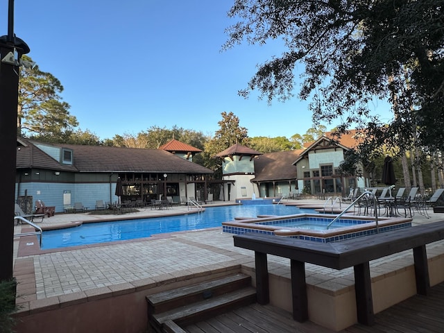 community pool with a community hot tub and a patio area
