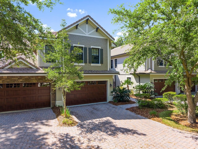 craftsman inspired home with driveway, stone siding, and a garage