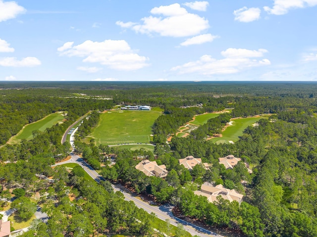 aerial view with view of golf course and a wooded view