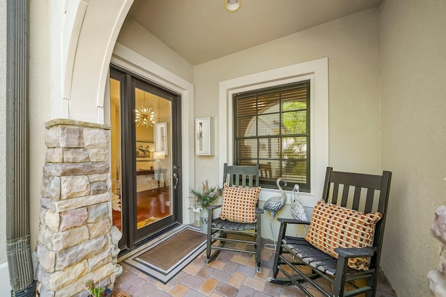 view of exterior entry with stucco siding and stone siding