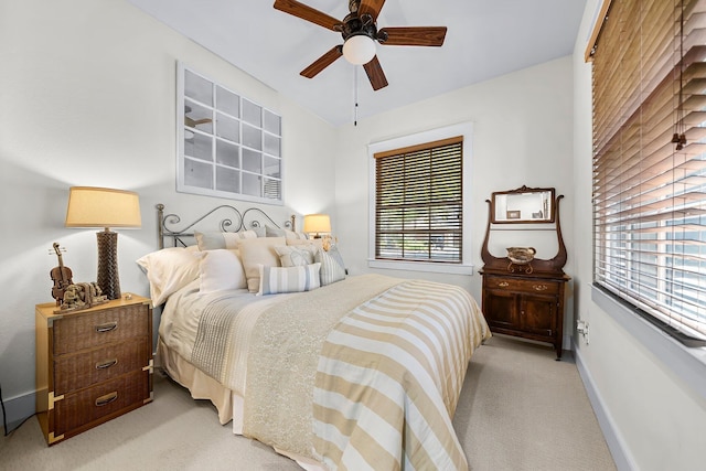 bedroom featuring baseboards, a ceiling fan, and light colored carpet