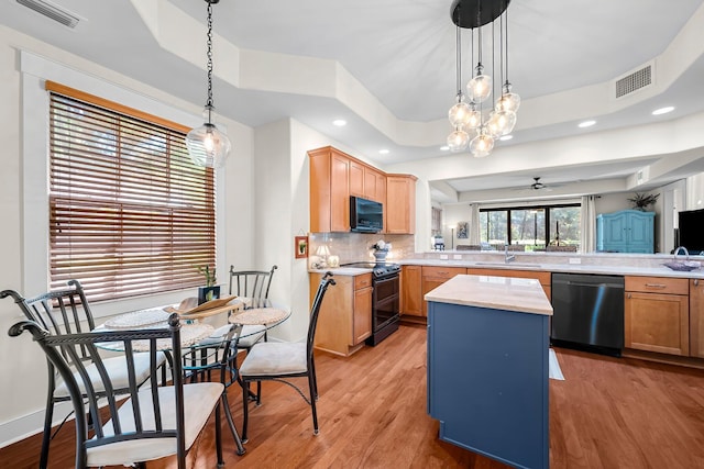 kitchen featuring a sink, a raised ceiling, black appliances, and visible vents