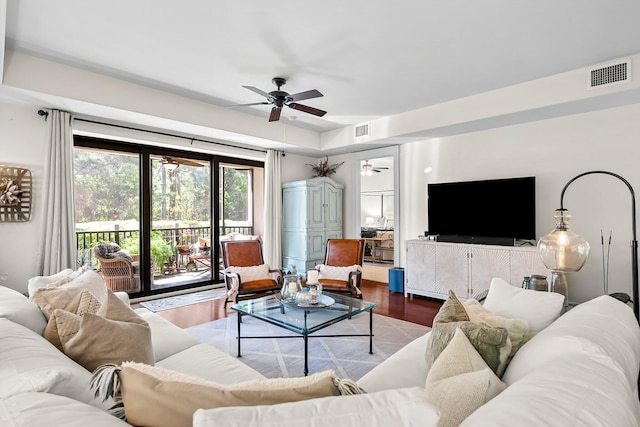 living area featuring visible vents, a ceiling fan, and wood finished floors