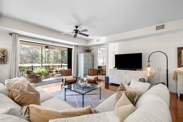 living area featuring visible vents, ceiling fan, and wood finished floors