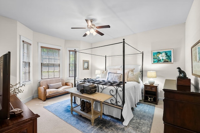 carpeted bedroom featuring baseboards and ceiling fan