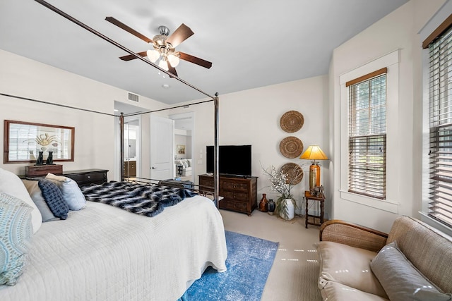 bedroom with carpet floors, ceiling fan, ensuite bathroom, and visible vents