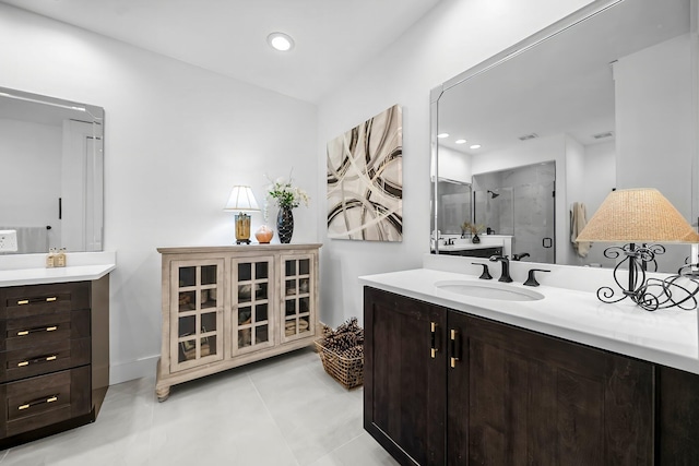 bathroom featuring two vanities, recessed lighting, a shower stall, and a sink