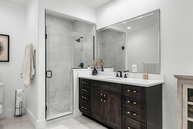 full bath featuring vanity, a marble finish shower, baseboards, and toilet