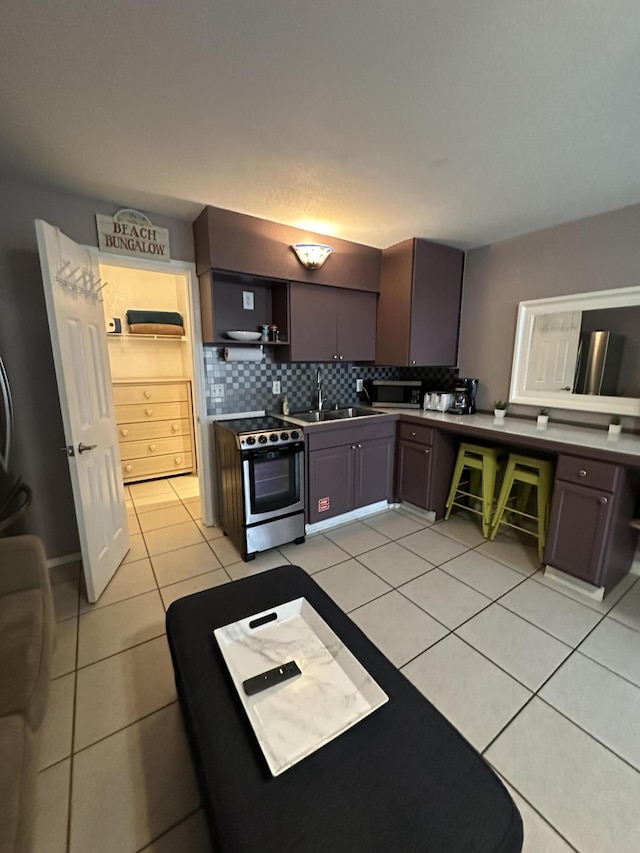 kitchen featuring stainless steel electric stove, a sink, open shelves, backsplash, and light tile patterned floors