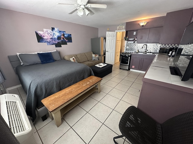 bedroom featuring a sink, light tile patterned floors, and freestanding refrigerator