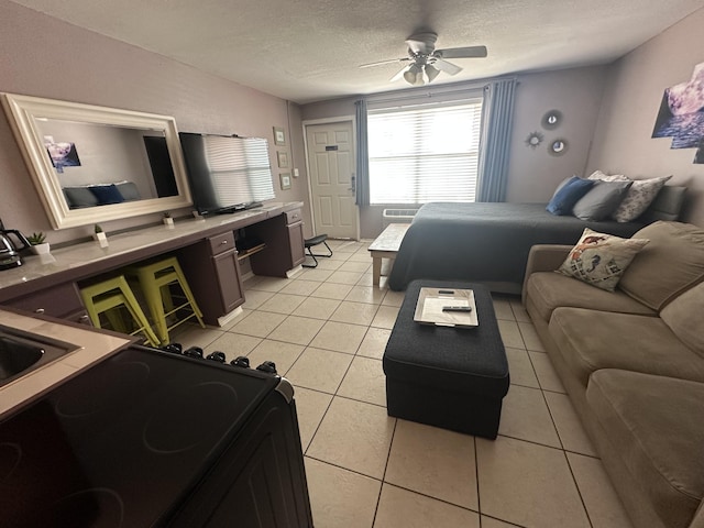 living room featuring a ceiling fan, a textured ceiling, and light tile patterned floors