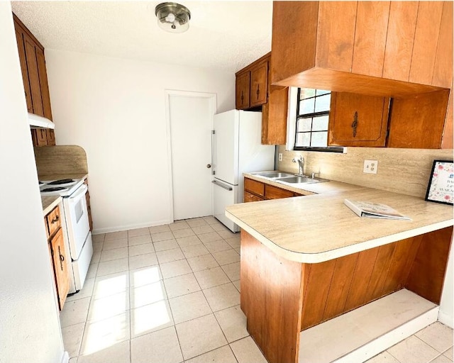 102 Alice Dr, Defuniak Springs, FL 32435 - kitchen with white appliances, a sink, under cabinet range hood, light countertops, and a peninsula