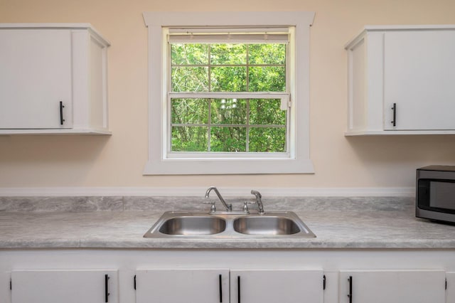 375 N Norwood Rd, Defuniak Springs, FL 32433 - kitchen featuring a sink, stainless steel microwave, white cabinets, and light countertops