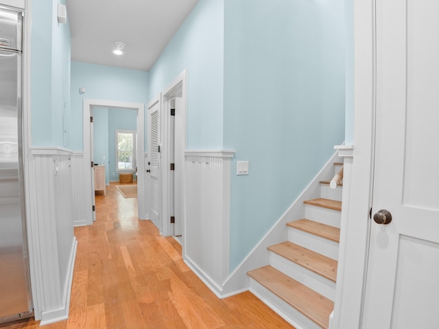 253 Salt Box Ln, Watersound, FL 32461 - hallway featuring light wood-type flooring, a wainscoted wall, and stairs