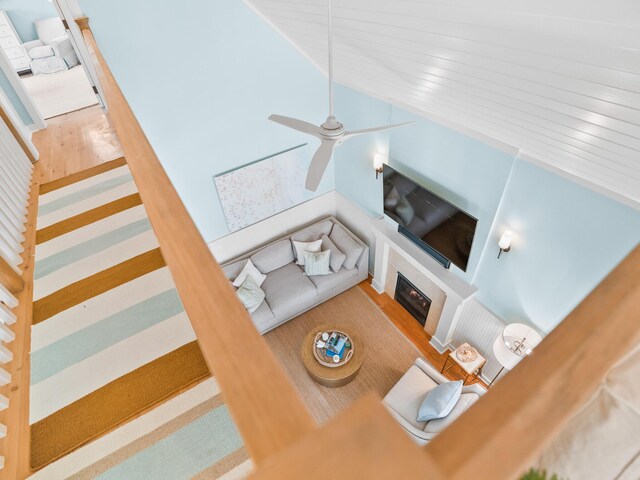 253 Salt Box Ln, Watersound, FL 32461 - living room featuring wood finished floors, ceiling fan, a glass covered fireplace, and vaulted ceiling