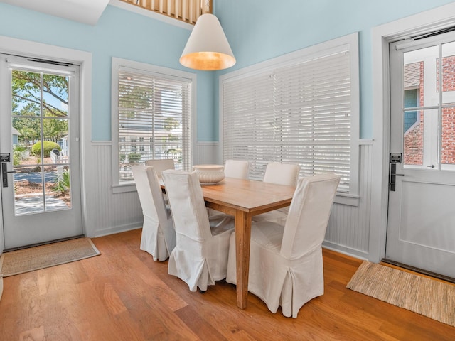 253 Salt Box Ln, Watersound, FL 32461 - dining space featuring wainscoting, light wood finished floors, and a decorative wall