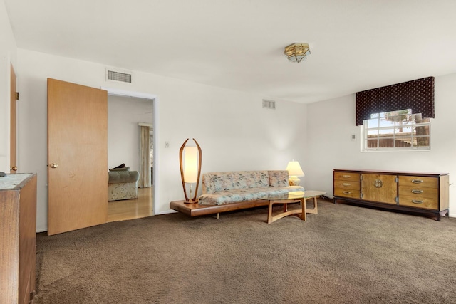 living area with visible vents and carpet