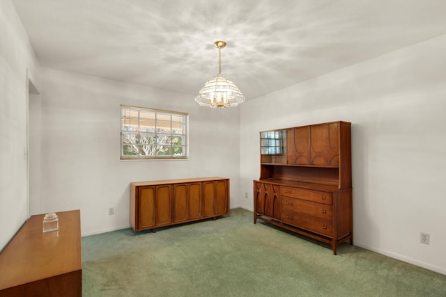 unfurnished room with baseboards, a chandelier, and light carpet