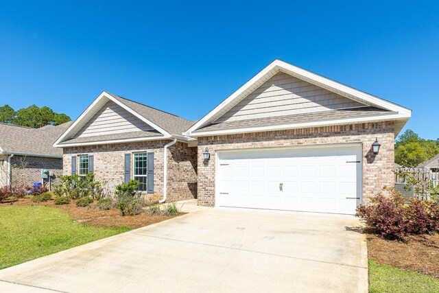 view of front of home with roof with shingles, an attached garage, a front lawn, brick siding, and driveway