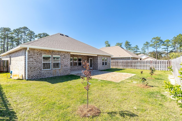 rear view of property with a patio, a fenced backyard, a lawn, and brick siding
