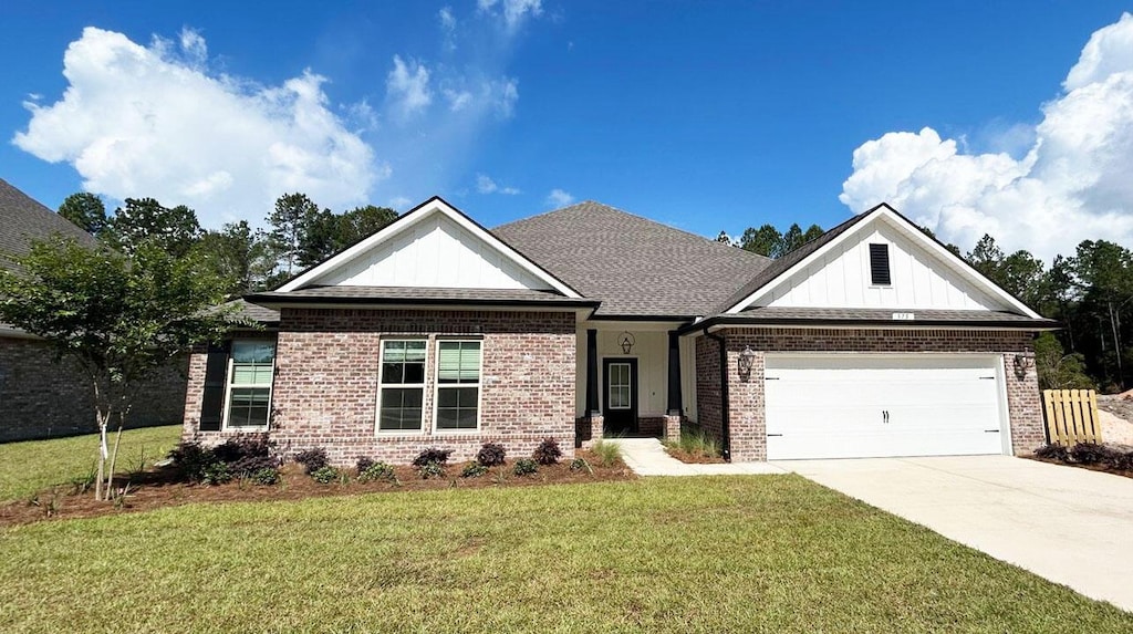 375 Kaleidoscope Cv, Freeport, FL 32439 - view of front of house with brick siding, board and batten siding, a front yard, concrete driveway, and a garage