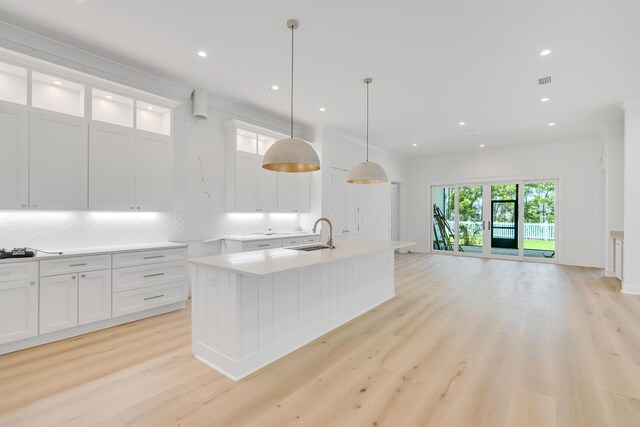 203 E Firethorn Cir Lot 24, Watersound, FL 32461 - kitchen featuring light wood finished floors, white cabinetry, a center island with sink, open floor plan, and light countertops