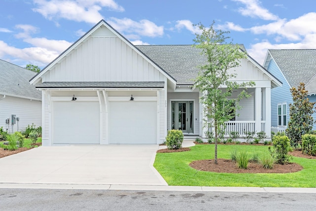 203 E Firethorn Cir Lot 24, Watersound, FL 32461 - view of front of property featuring board and batten siding, an attached garage, covered porch, driveway, and a shingled roof
