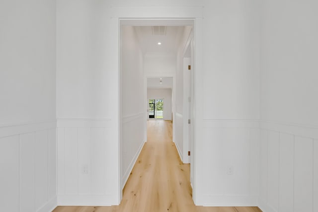 203 E Firethorn Cir Lot 24, Watersound, FL 32461 - hallway with light wood-style floors, a wainscoted wall, and a decorative wall