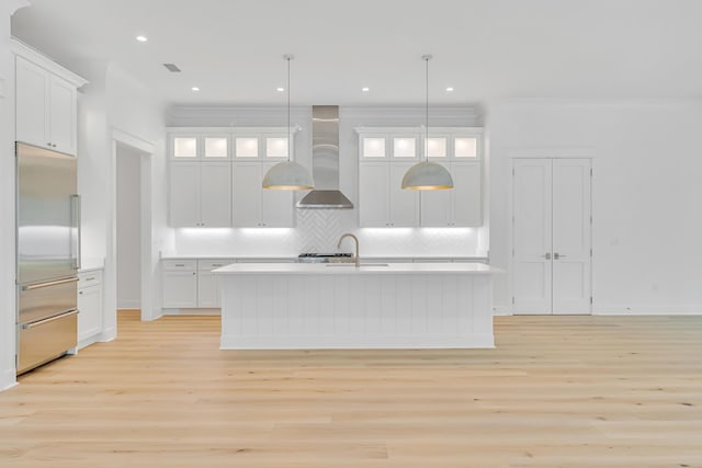 203 E Firethorn Cir Lot 24, Watersound, FL 32461 - kitchen featuring built in fridge, wall chimney range hood, light wood-style floors, light countertops, and crown molding