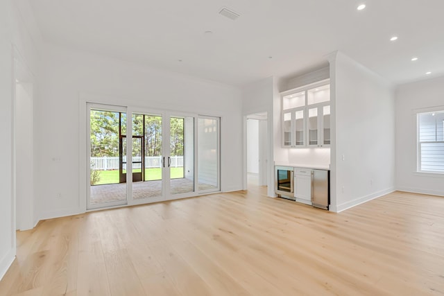 203 E Firethorn Cir Lot 24, Watersound, FL 32461 - unfurnished living room featuring wine cooler, light wood-type flooring, a bar, and recessed lighting