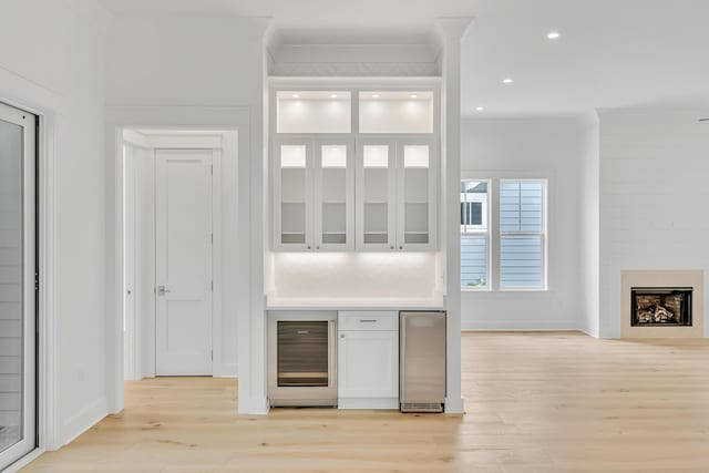 203 E Firethorn Cir Lot 24, Watersound, FL 32461 - indoor dry bar with beverage cooler, light wood-type flooring, recessed lighting, crown molding, and a fireplace