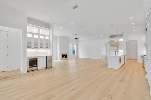 203 E Firethorn Cir Lot 24, Watersound, FL 32461 - unfurnished living room with wine cooler, ceiling fan, light wood finished floors, recessed lighting, and bar