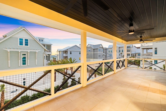 patio terrace at dusk with a residential view and a ceiling fan