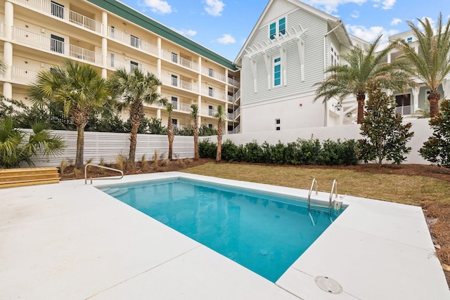 view of swimming pool with a patio and fence