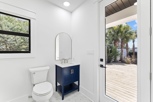 bathroom featuring marble finish floor, vanity, toilet, and baseboards