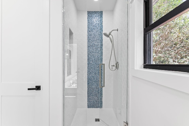 bathroom with a healthy amount of sunlight and a shower stall
