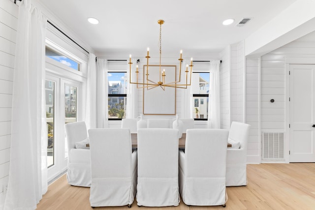 dining room with visible vents, an inviting chandelier, and light wood-type flooring