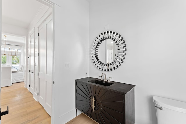 corridor featuring wood finished floors and a sink