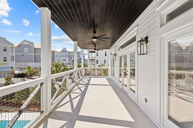 view of patio with a balcony, french doors, a ceiling fan, and a residential view
