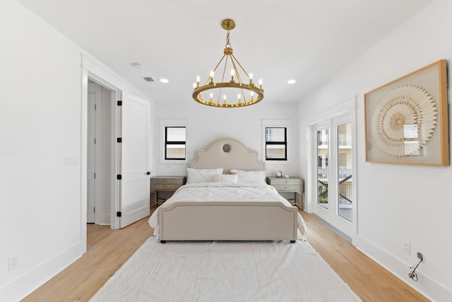 bedroom with access to outside, light wood-type flooring, baseboards, and an inviting chandelier