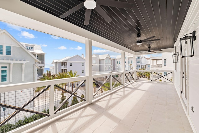 view of patio featuring a balcony, ceiling fan, and a residential view