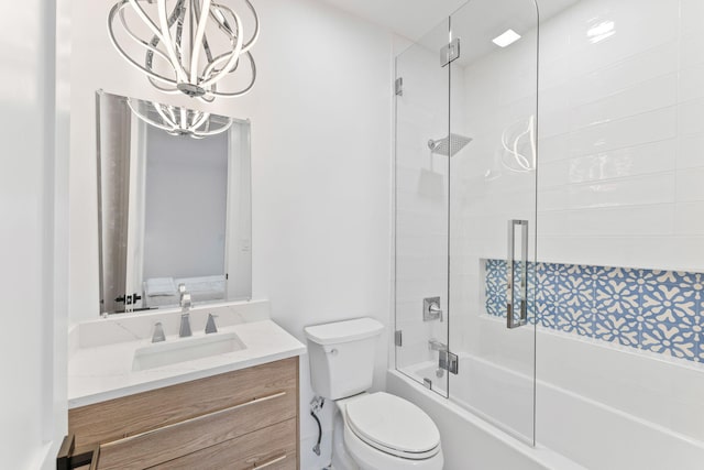 bathroom featuring toilet, a chandelier, vanity, and shower / bath combination with glass door