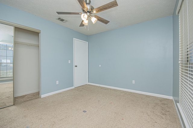 unfurnished bedroom with a closet, a textured ceiling, visible vents, baseboards, and carpet floors
