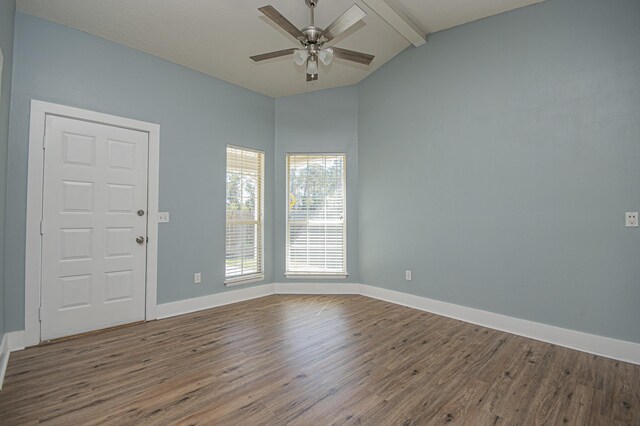 unfurnished room with baseboards, wood finished floors, a ceiling fan, and lofted ceiling with beams