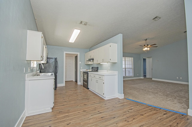 kitchen with visible vents, under cabinet range hood, a sink, electric range oven, and open floor plan