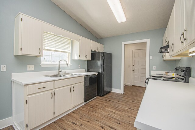 kitchen featuring vaulted ceiling, light wood-type flooring, under cabinet range hood, a sink, and black appliances