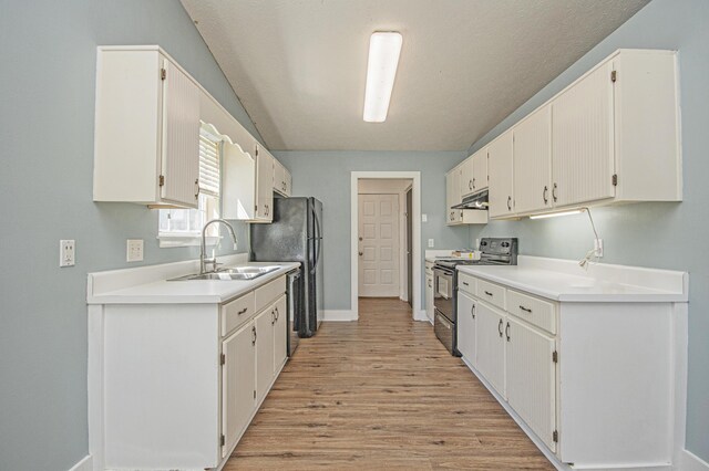 kitchen with light countertops, under cabinet range hood, electric stove, a sink, and white cabinets