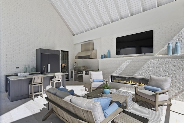 view of patio / terrace featuring grilling area, exterior bar, an outdoor living space with a fireplace, and area for grilling